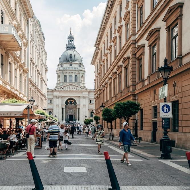 City street with pedestrians and a busy sidewalk cafe