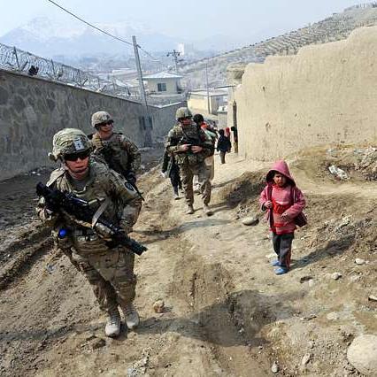 		Armed soldiers walk up an incline alongside five children in colorful clothing. It's peaceful
	