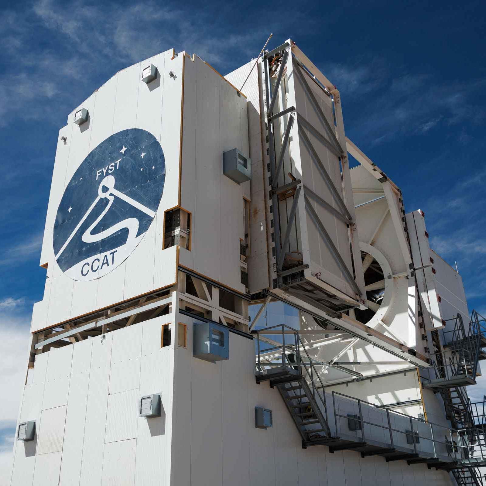 The telescope, a large white structure with the logo on the front, rises three stories in the air.