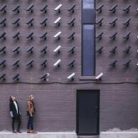 Two people face many security cameras