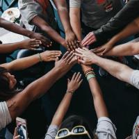 People placing their hands together in a circle