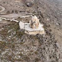 Ancient stone building in a rocky landscape, seen from above