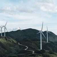 Wind turbines in a green, hilly landscape