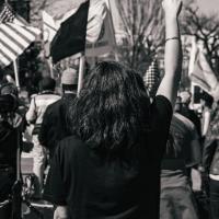 A woman standing with her fist upraised at a protest at the White House