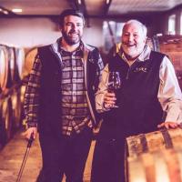 two men by barrels of wine