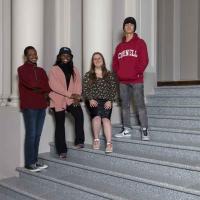 four students on stairs 