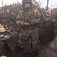Solder wearing battle-worn clothing, eating out of a cup