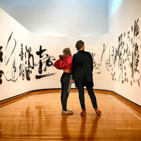  Two people surrounded by a work of art