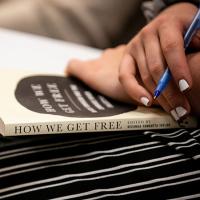  The book &quot;How We Get Free&quot; on someone&#039;s lap
