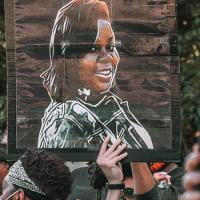 A poster with a drawing of Breonna Taylor carried aloft during a protest