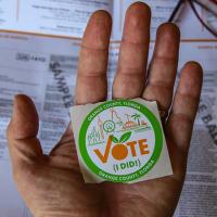  Hand holding a &quot;Vote&quot; sticker