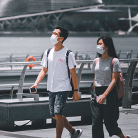  Two people walking, wearing masks
