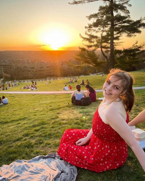 girl on slope of hill during sunset