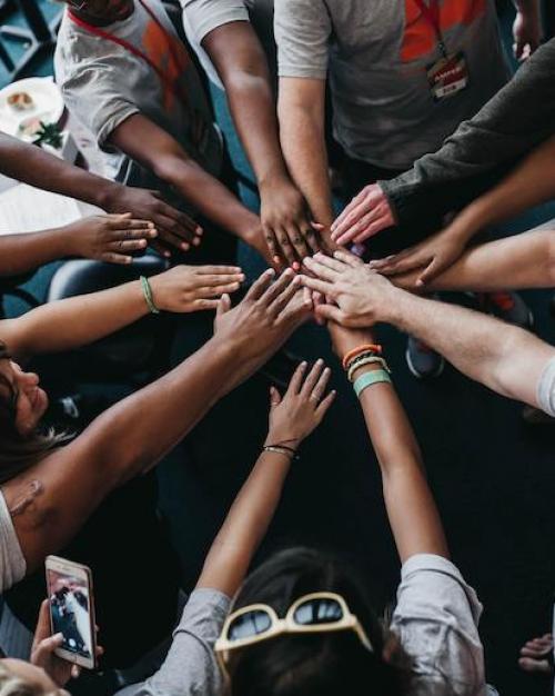 People placing their hands together in a circle