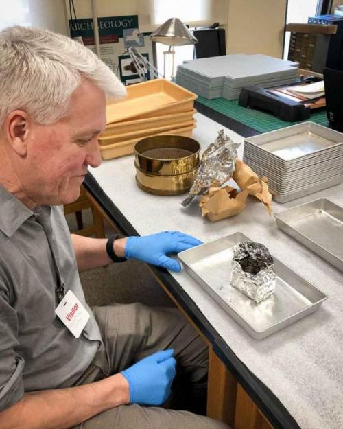 man looking at a piece of charcoal