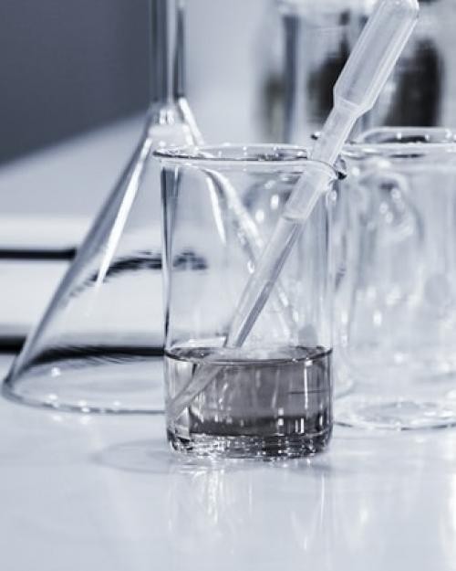 Lab beakers, one partly filled with liquid