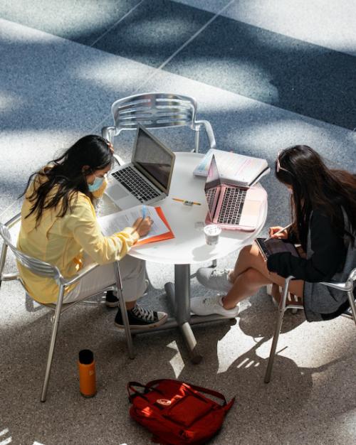 Two people study at a table, seen from above