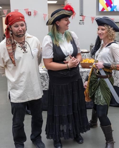 Three people dressed as pirates pose