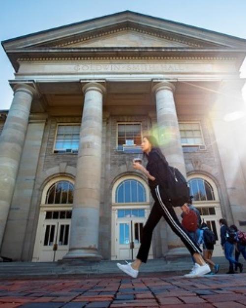 		woman walking in front of Goldwin Smith
	