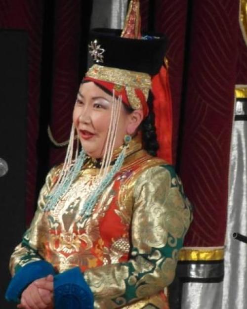 		Person singing in a brightly colored traditional costume of Mongolia
	