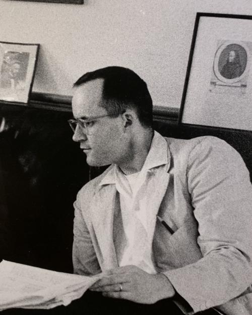 Historical black and white image of a young man reading