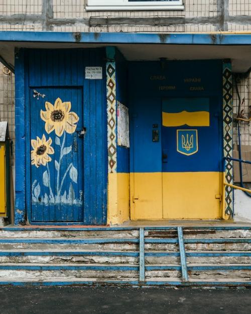Doorway to a building, painted in bright blue and yellow with sunflowers