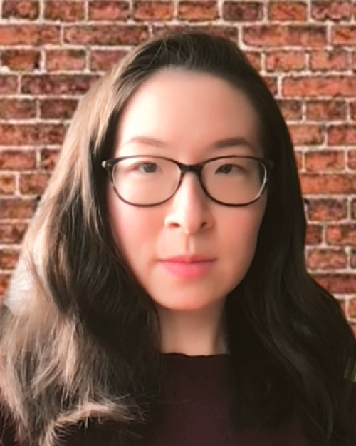 		Rhoda Feng, wearing big black glasses, long hair and a serious expression
	