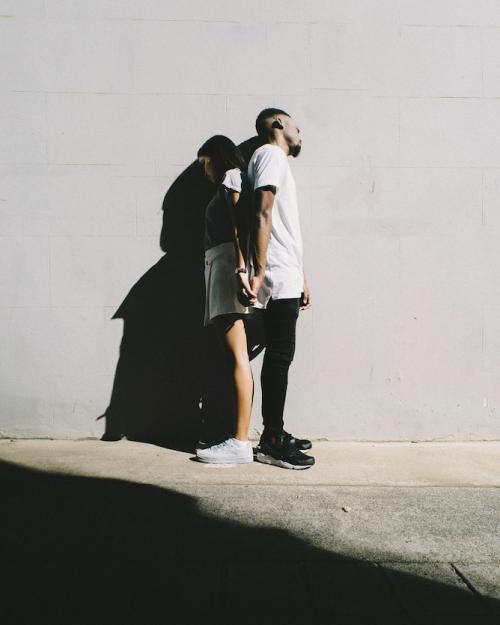 		Two people leaning back to back against a wall, shadowed
	