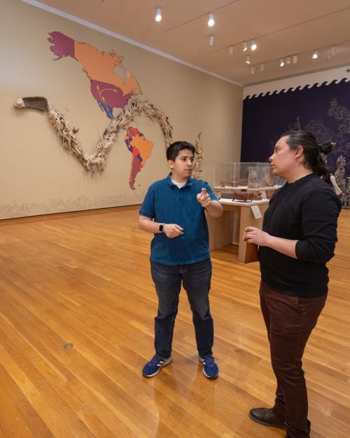 		two people standing in a museum exhibit
	