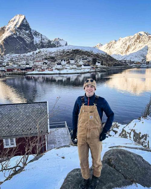 person standing by a lake in winter