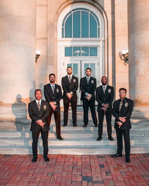 people in suits on stairs of Goldwin Smith Hall