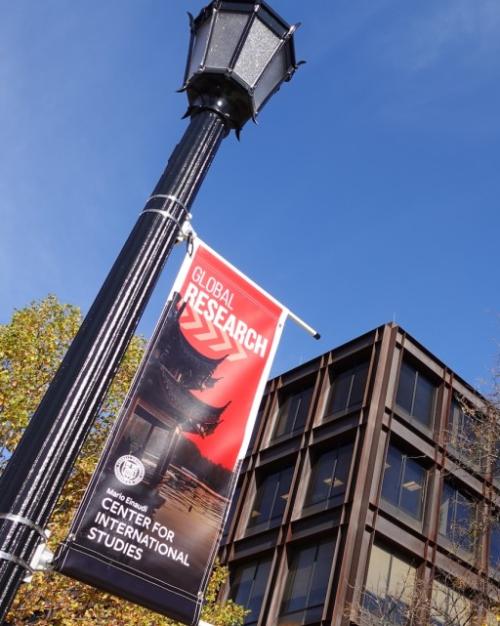 Black lamp post holding up a red poster that says Global Research