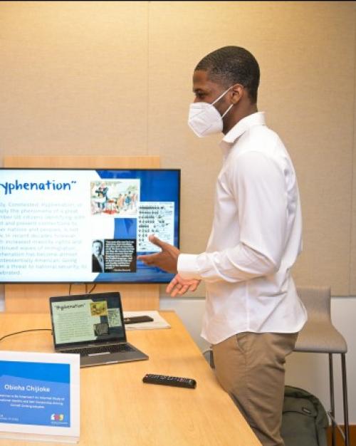 		Two people converse over a table, with a computer screen at one end
	
