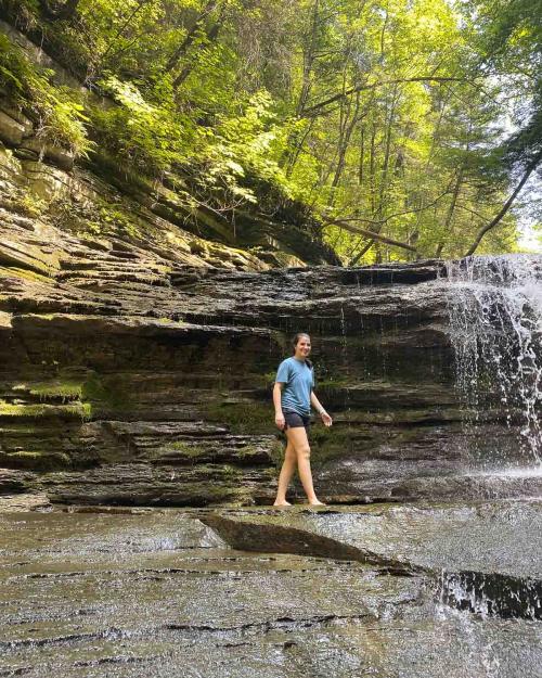 person walking by a waterfall