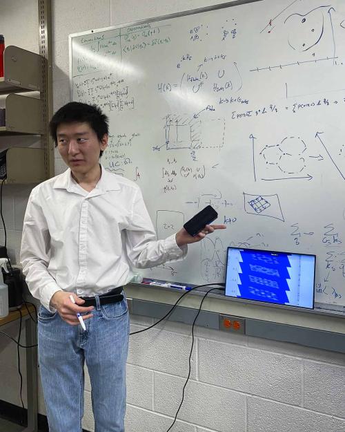 person standing at whiteboard filled with equations