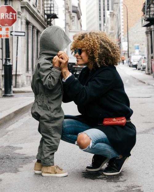 		A mother helping a child with the hood of a parka
	