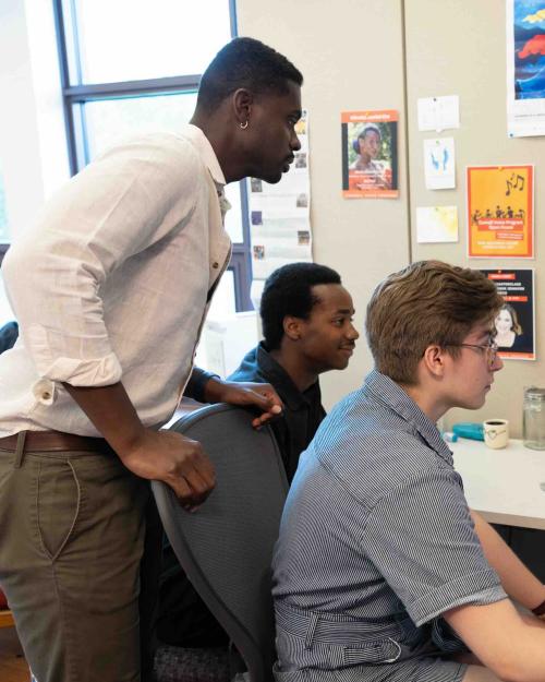 		three people working on a computer
	