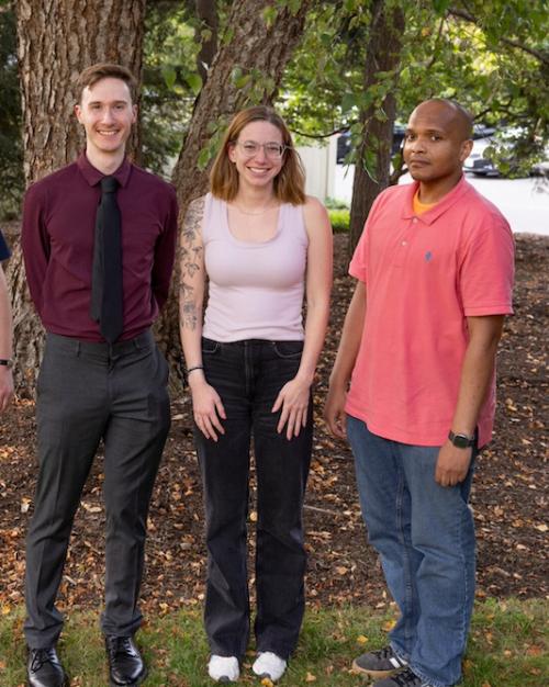 		Five people standing in a line under a tree
	