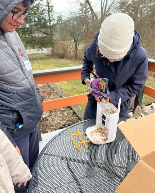 		people fixing a bird feeder
	