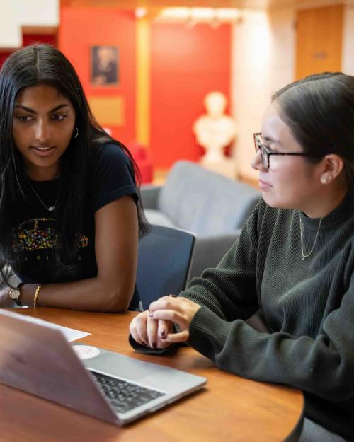 Two people looking over a text on a computer 