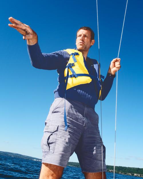 		Person wearing a yellow life jacket, standing up in a boat
	