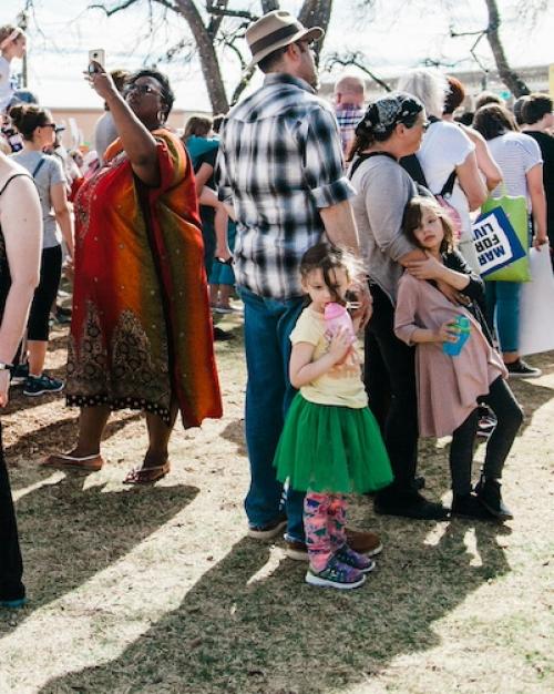 		Dozens of people standing on a lawn, at a public rally
	