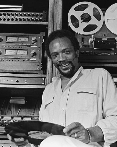 		Person holding an LP in front of recording equipment in a studio
	