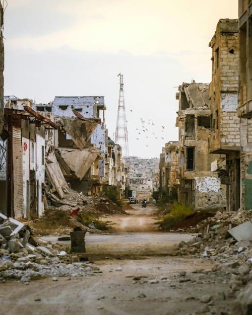 		Looking down a desolate street damaged by war
	