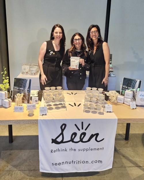 		Three people stand behind a product table for "Seen Nutrition"
	