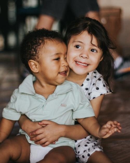 Two kids sitting on a floor