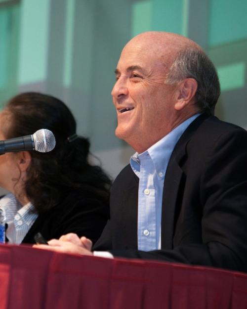 David Easley, sitting at a presentation table with a microphone