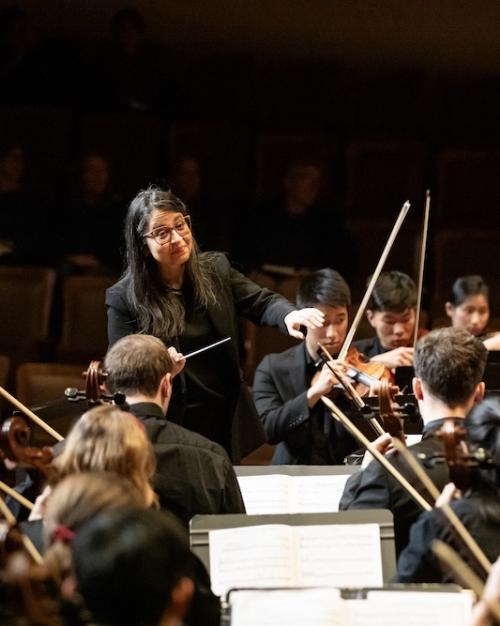 A conductor directs an orchestra