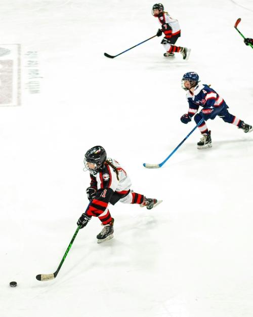 		Four young ice hockey players, skating
	