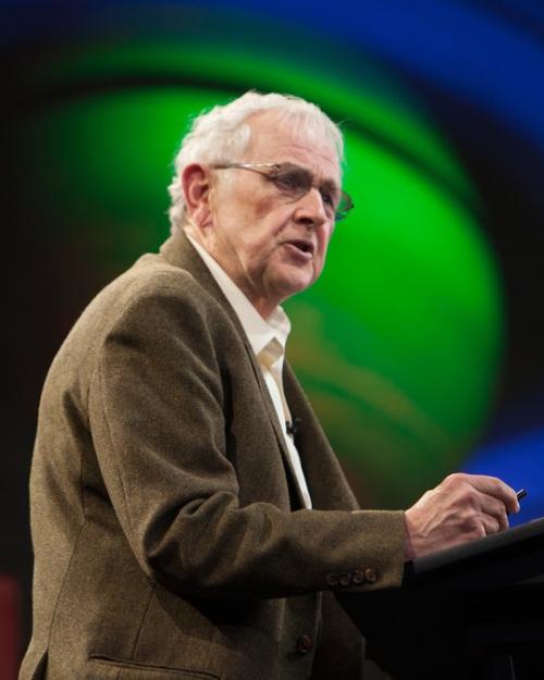 		Person speaking at a podium with an image of a planet in the background
	